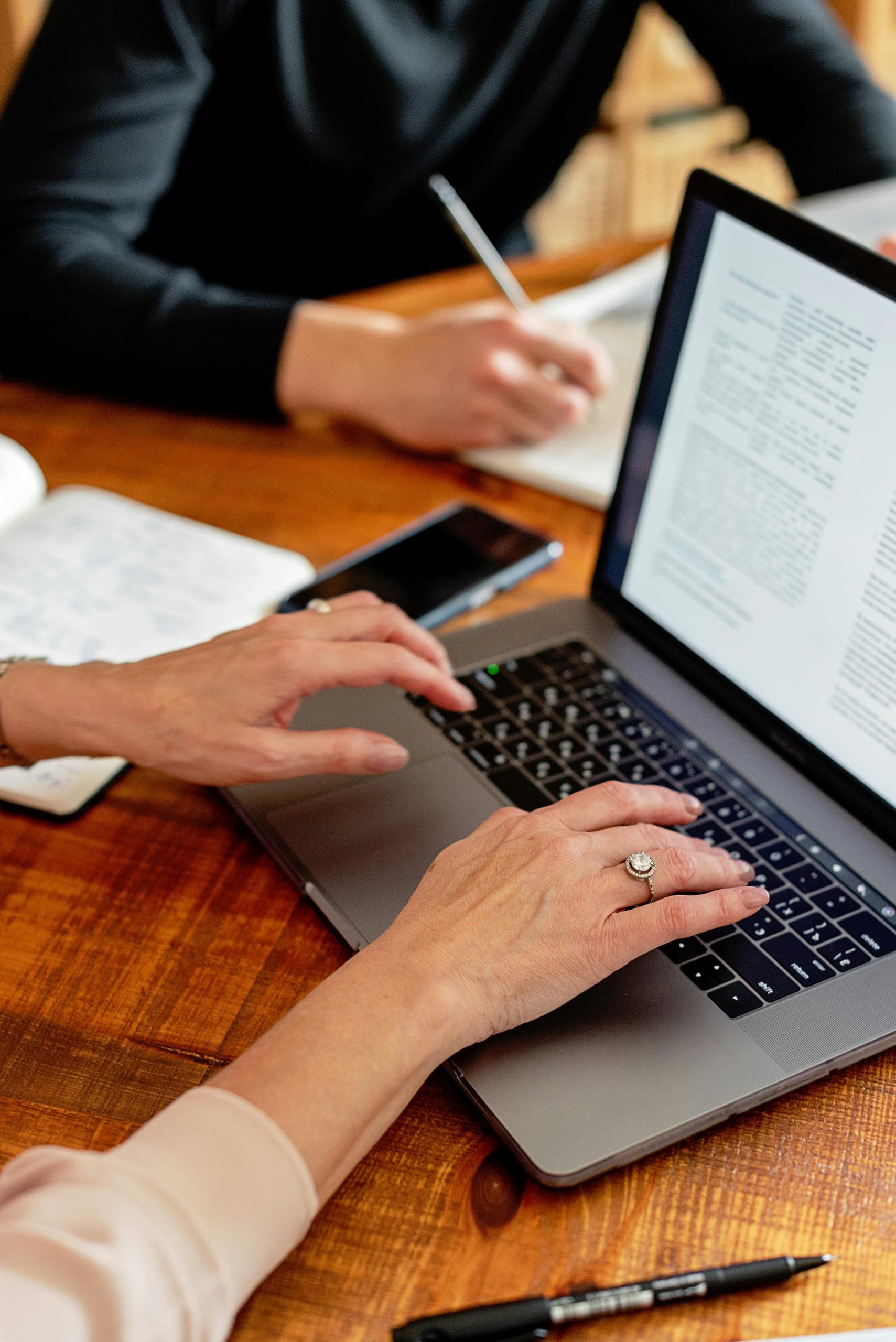 Handwritten notes and a laptop open to a draft document