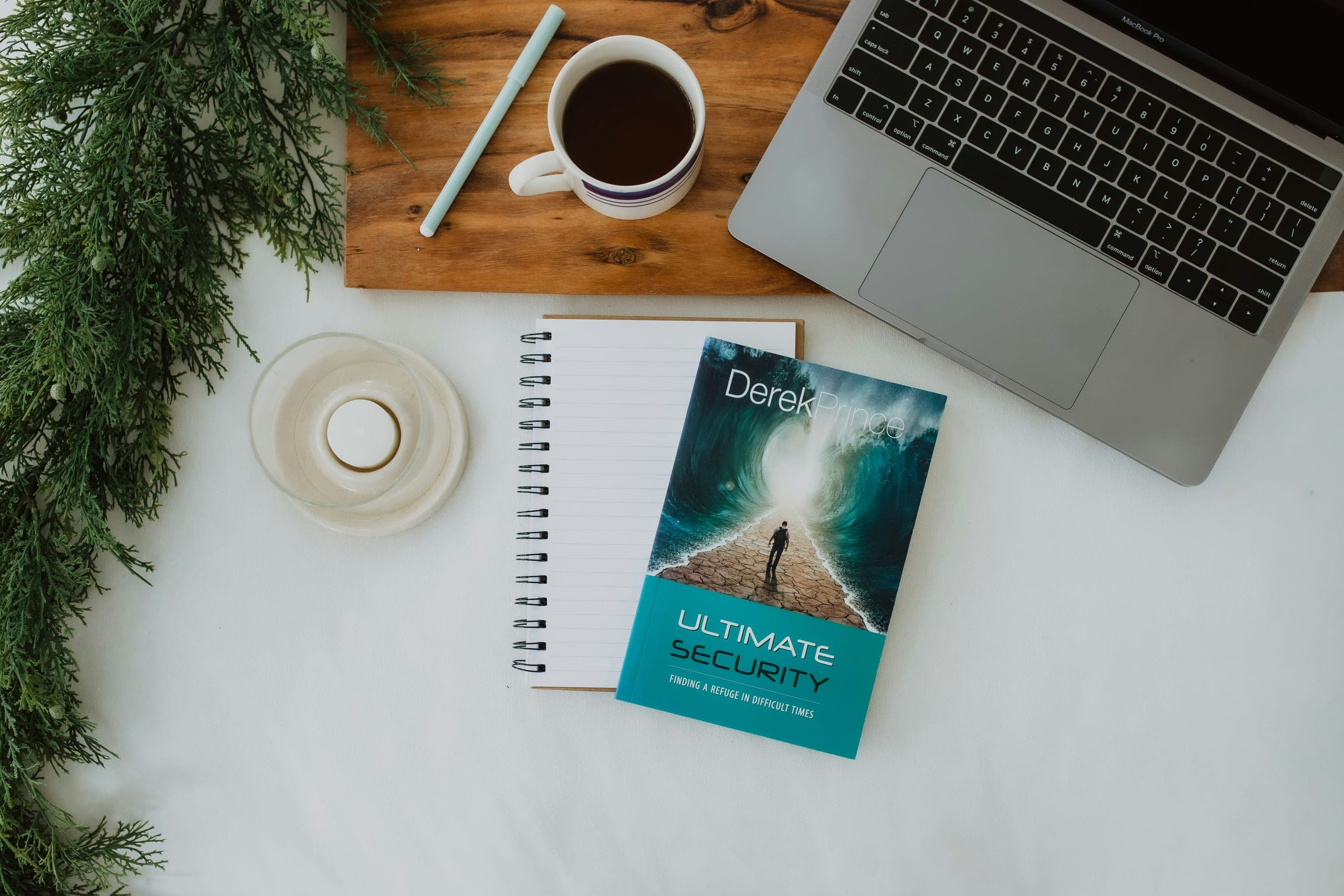 Open books, a notebook, and a coffee on a wooden desk